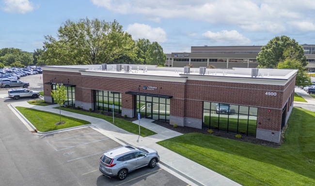 an aerial view of a building with a car in a parking lot